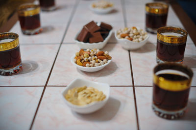 Nuts with chocolates by black coffee on table at cafe