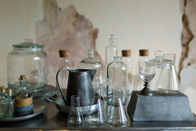 Empty chairs and table with glassware against wall at home