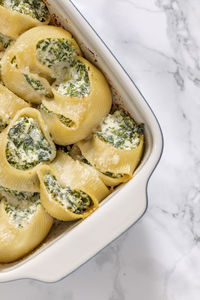 Baked stuffed lumaconi pasta with ricotta cheese and spinach. 