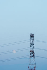 Low angle view of electricity pylon against clear sky