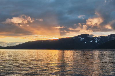 Scenic view of a beautiful and colorful sunset over mountains and sea in norway