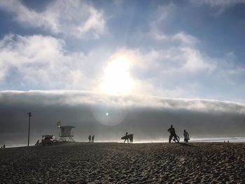 People on beach against sky