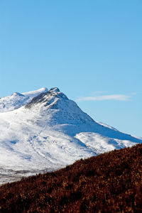 Scenic view of snowcapped mountains against clear blue sky