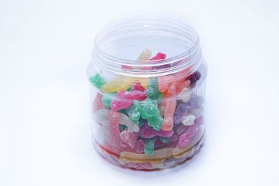 Close-up of multi colored jar against white background