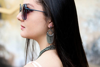 Close-up of beautiful young woman wearing sunglasses while standing outdoors