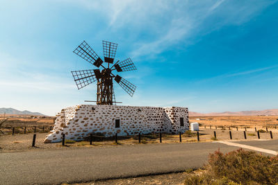 Traditional windmill on field against sky