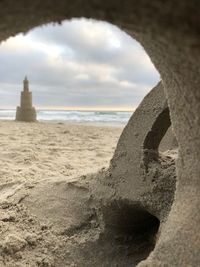 Sand castle at beach against sky
