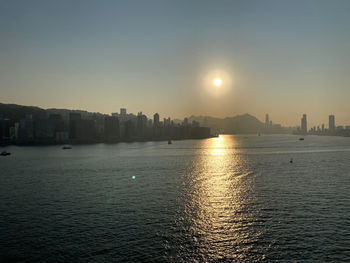 Scenic view of sea and buildings against sky during sunset