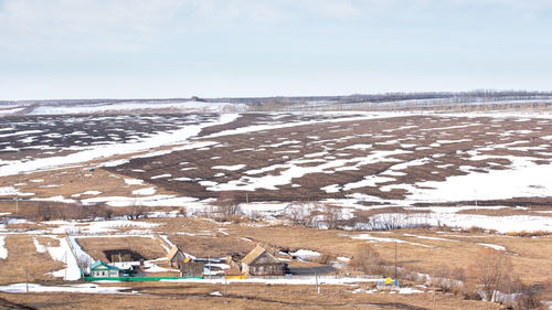 Scenic view of snow covered land against sky