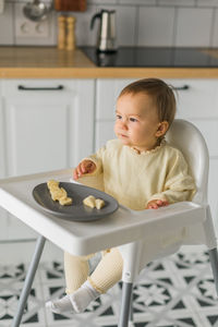 Portrait of cute baby boy sitting on table