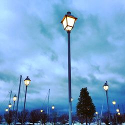 Low angle view of illuminated street light against sky