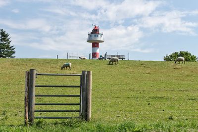 View of lighthouse on field against sky