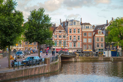 View of canal by buildings against sky