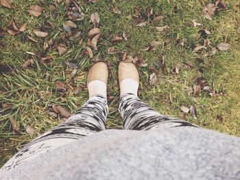 Low section of woman standing on field