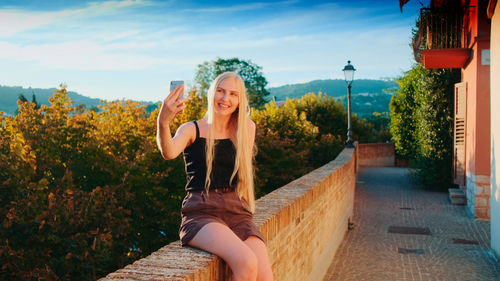 Full length of young woman exercising in city