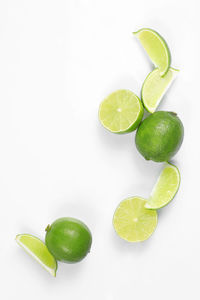 High angle view of green fruit over white background