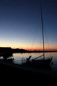 Silhouette sailboats in sea against sky during sunset