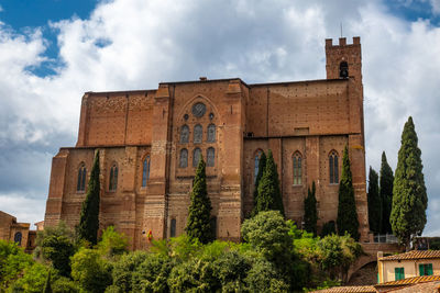 Low angle view of historical building, san domenico  basilica in siena, italy, against sky