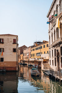 Small wooden boat filled with construction rubbish moored on a narrow canal in venice, italy.