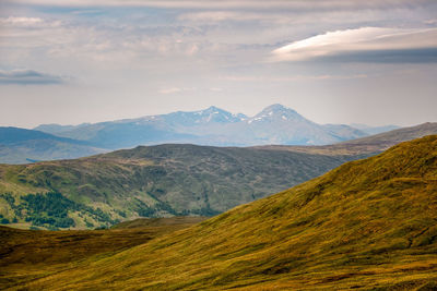 Scenic view of valley and mountains against sky