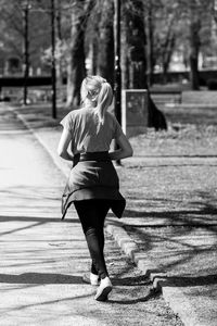 Full length portrait of woman walking on footpath