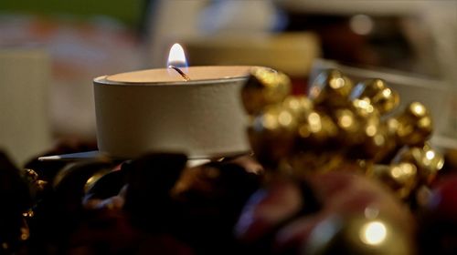 Close-up of illuminated candles on table in building