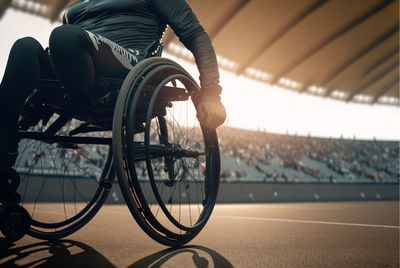 Close up of man in wheelchair sports on an outdoor running track. disabled athlete concept. 