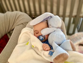 Cute baby boy sleeping in blanket at home