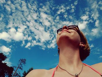 Low angle view of woman against blue sky