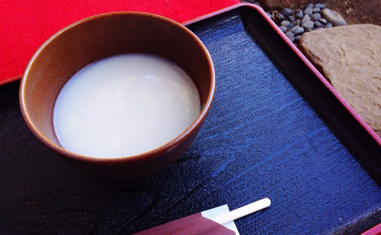 indoors, table, still life, high angle view, food and drink, close-up, coffee cup, directly above, drink, wood - material, freshness, coffee - drink, spoon, no people, refreshment, cup, red, sweet food, book, coffee