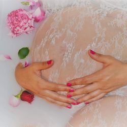 Midsection of pregnant woman having milk bath