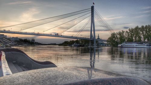 Bridge over river in city against sky