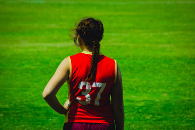 Rear view of woman standing on field