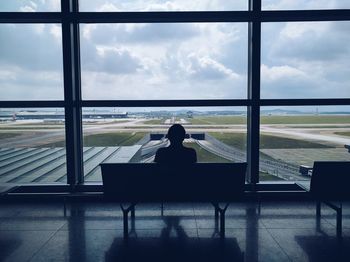 Rear view of man and woman sitting at airport