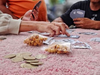 Cropped image of people playing card at table