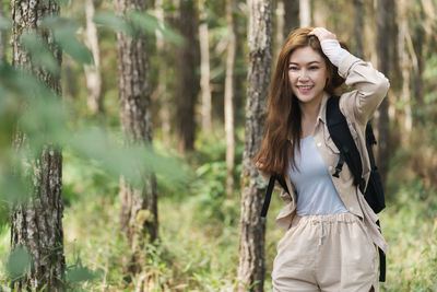 Young woman standing in forest