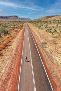 Man riding motorcycle on road against sky