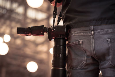 Midsection of man holding camera