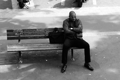 Full length of man sitting outdoors