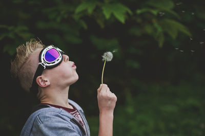 Close-up of boy blowing dandelion