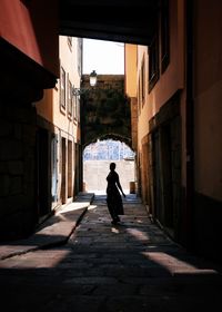 Woman standing on street amidst buildings in city