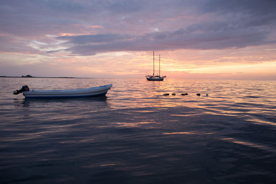 Sailboat in sea at sunset