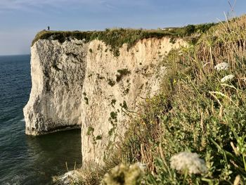 Rock formations by sea against sky