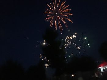 Low angle view of fireworks in sky at night