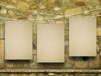 Close-up of blank papers hanging against wall