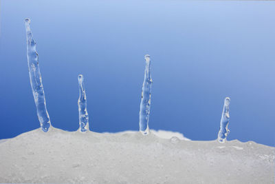 Close-up of icicles on sea against clear sky