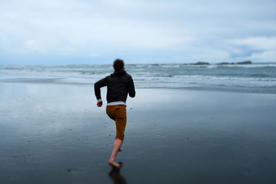 Rear view of man running at beach