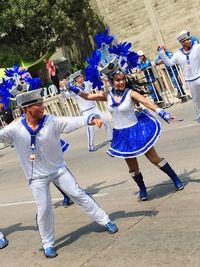 Group of people dancing on street in city