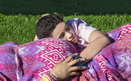 Midsection of woman lying on grassy field