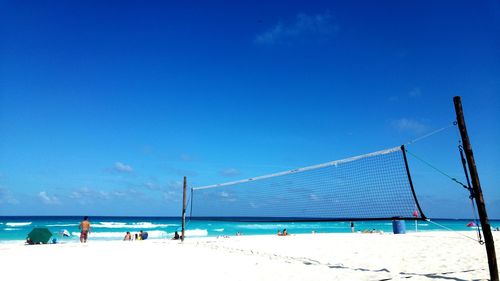 People on beach against blue sky